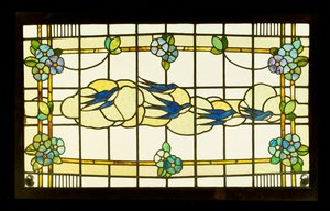 Panel Arts and Crafts skupiny vlaštovek před mraky na okraji stylizovaných květinových hlav (olovnaté a barevné sklo) od English School