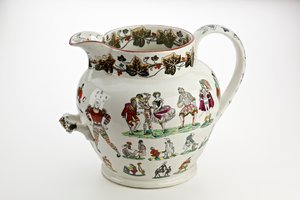 Staffordshire džbán zdobený figurkami Harlekýna a karnevalovým motivem, 1866 (železný porcelán)