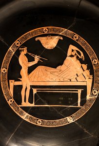 Pohár: symposiast a mladý otrok hrající na dvojitý aulos (červenofigurová keramika,) od Euaion painter