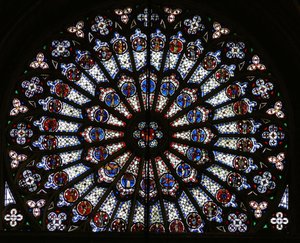 Růžové okno zobrazující Krista obklopeného symboly dvanácti apoštolů a evangelistů od French School