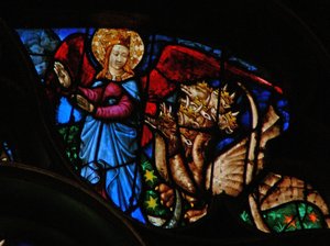 Západní rozeta zobrazující scénu z Knihy Zjevení: drak pronásleduje matku muže; ale má křídla, jimiž může létat do pustiny (12:13 14). od French School