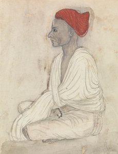 Muž v červeném turbanu sedí se zkříženýma nohama