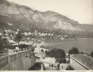 Panoramatický výhled na Montecarlo v Monaku. Scéna ukazuje různé kolemjdoucí; vlevo vidíme detailní záběr na mramorovou balustrádu od Giacomo Brogi