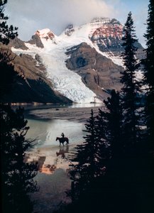 Osamělý kůň a jezdec se odrážejí od jezera na úpatí nejvyššího vrcholu Kanady. Mount Robson... od James L Stanfield