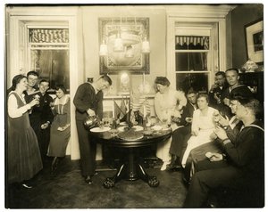 Alice Foote MacDougalová baví skupinu námořníků ve svém malém bytě ve staré válce, Greenwich Village, New York, USA, cca 1917-18 (želatinová stříbrná fotografie)