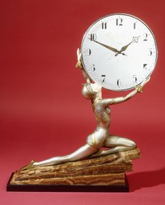Klečící dívka s hodinami (bronz a slonovina, chromované kovové hodiny, hnědý pruhovaný mramorový bas)