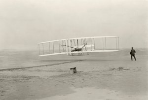 Wright Flyer I uskutečnil svůj první let z výšky 120 stop za 12 sekund v Kitty Hawk v Severní Karolíně. od John T. Daniels
