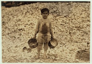 5letý migrující sběrač krevet Manuel před hromadou lastur ústřic, pracující druhý rok v Dunbar, Lopez, Dukate Company, Biloxi, Mississippi, 1911 od Lewis Wickes Hine