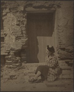 [Žena sedící před chátrající budovou] od Louis Fleckenstein