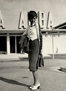 Model oblečení soubor vytvořený couture house "Graldi". Outfit se skládá z obleku s dvoubarevnou halenkou. Pevný klobouk doplňuje soubor. (černobílá fotografie)