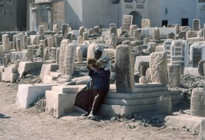 Jemenský muž recituje Korán na hřbitově s hrobkami v Sajunu, Hadramawt, jižní Jemen.
