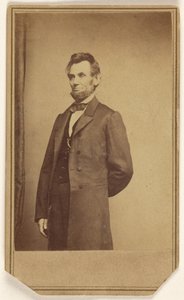 [Abraham Lincoln stojí s jednou rukou za zády]