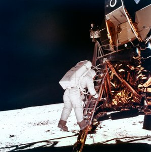 Edwin Buzz Aldrin sestupuje po schodech žebříku lunárního modulu, aby se prošel po Měsíci, 1969.