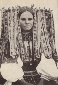 Česká žena s čelenkou ze stuh, kde každá stuha označuje nápadníka, kterého odmítla vdát (černobílá fotografie)