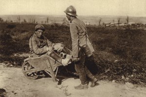 Zajatý francouzský voják převážející svého zraněného kamaráda na kolečku, první světová válka od Photographer German