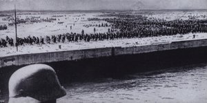 Německý voják provádějící průzkum spojeneckých zajatců na pláži u Dunkerque ve Francii, druhá světová válka, červen 1940 (černobílá fotografie) od Photographer German