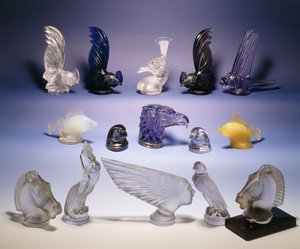 Různé skleněné maskoti aut (ptáků, ryb, koní a lidské hlavy) od Rene Jules Lalique