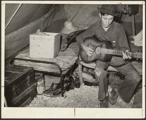 Bílý migrující sběrač jahod na posteli ve stanu poblíž Hammondu, Louisiana od Russell Lee