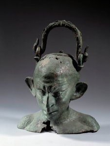 Bronzová váza ve tvaru hlavy: busta syrského otroka (?). 2. nebo 3. století po JC. Ne 0,19 m Paříž, Musee du Louvre
