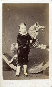 Chlapec stojící u houpacího koně od Silas Eastham