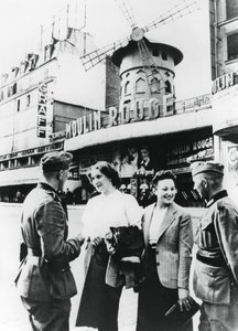 Němečtí vojáci si povídají s Francouzkami před Moulin Rouge, okupovaná Paříž, červen 1940 od Unbekannt
