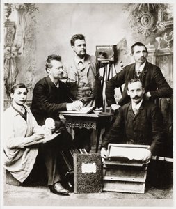 "Skupina fotografů a asistentů s vybavením" od Unbekannt