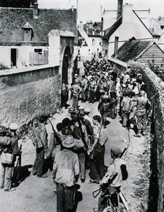 Skupiny bojovníků francouzského odporu čekají na distribuci zbraní v domě, červenec 1944 (č/b foto) od Unbekannt
