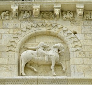 Románské umění: detail fasády zobrazující Huguese de Surgeres a Geoffroye de Vendome nebo císaře Konstantina I. Velikého, jehož noha koně šlapala Heresie a Kristus vítězící nad zlem a smrtí, Notre Dame (Notre-Dame) de Surgeres (17700) od Unbekannt