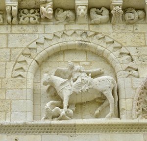Románské umění: detail fasády zobrazující Huguese de Surgeres a Geoffroye de Vendome nebo císaře Konstantina I. Velikého, jehož noha koně šlapala Heresie a Kristus vítězící nad zlem a smrtí, Notre Dame (Notre-Dame) de Surgeres (17700) od Unbekannt