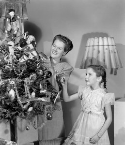 Žena a dívka zdobí vánoční stromek, c 1948 od Unbekannt