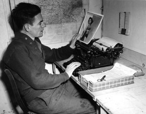 Druhá světová válka (1939-1945) – Druhá světová válka (2. světová válka nebo 2. světová válka): Mutzig (Alsasko) Francie 1. prosince 1944: Desátník Flanerty kronikář z Beachead News (zpravodajského deníku GI) se dívá na fotografii, kterou publikuje v příšt od Unbekannt