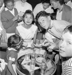 HEREČKA A MÓDNÍ MODELKA ELSA MARTINELLI NA XVIII. MEZINÁRODNÍM FILMOVÉM FESTIVALU V BENÁTKÁCH LIDO (podepisuje se mladým fanouškům. Na stole láhev Schweppes) - 1957 od Unbekannt