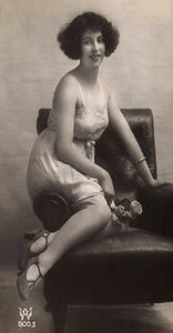 Mladá žena pózuje ve spodničce a sedí v křesle. od Unknown photographer