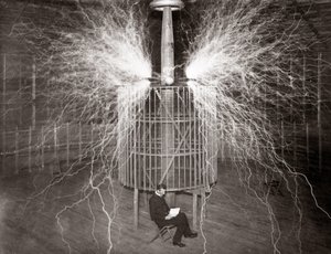 Nikola Tesla sedí ve své laboratoři v Colorado Springs se svým „zvětšovacím vysílačem“ od Unknown photographer