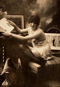 Portrét mladé ženy v intimním oděvu, sedící u stolu s knihou. od Unknown photographer