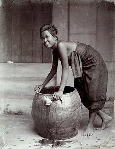 Mladá usměvavá Thajka, která tlačí velký kontejner od Unknown photographer