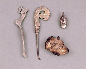 Různé kusy aparátů a vikingských šperků, vpravo nahoře znázornění božstva Odina. Stockholm, Historická Museet