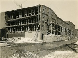 Staveniště, dva muži stojící v otevřené straně budovy skladu; Robbins und Ripley Engineers and Contractors, 23. března 1916 od William Davis Hassler