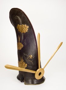 Kawari-Kabuto neboli „mimořádná helma“ ve tvaru dvořanské čepice (železo, lak, kůže, textil, zlato, slitiny mědi a dřevo) od Yoshimichi Myochin