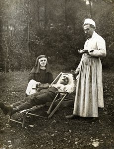 Lékař snímající puls zraněného muže, asistovala mu sestra jeptiška, cca 1900 (č/b foto) od . .