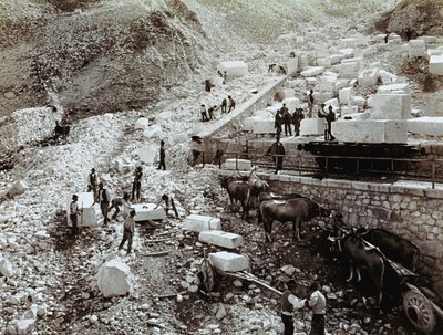 Nádraží s dělníky nakládajícími mramorové bloky na železniční vagóny, jsou vidět tři páry volů s transportními vagóny (č/b foto) od Fratelli Alinari