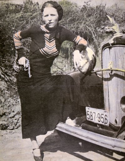 Bonnie Parker pózující „tvrdá“ se zbraní a doutníkem, kolem roku 1934 (černobílá fotografie) od American Photographer