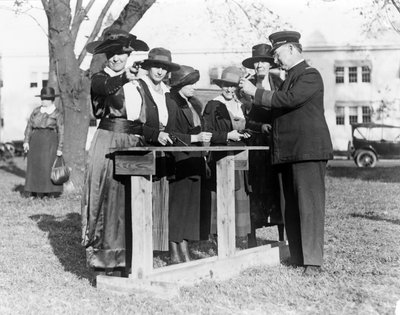 Policista učící ženy střílet, kolem roku 1920 od American Photographer