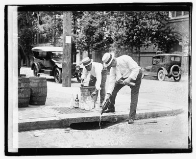 Dva muži nalévali kořalku do stoky, 8. července 1921 (černobílé foto) od American Photographer