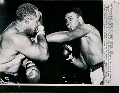 Mladý Cassius Clay skóruje levou proti veteránovi Archie Mooreovi v prvním kole boje v Los Angeles od American Photographer
