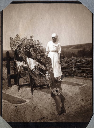 První světová válka 1914-1918: zdravotní sestra (Therese Pavillou?) v blůze na hrobě francouzského pilota seržanta Rouxe, který zemřel ve věku 21 let v Couville, Manche, Basse-Normandie (Dolní Normandie), Francie. Anonymní fotografie červenec 1917. Soukrom od Anonymous Anonymous