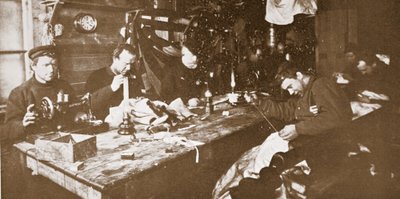 V Chatě uprostřed zimy se muži zabývali šitím kožešin na oděvy pro jarní sáňkování, hospoda. Londýn 1907 (černobílá fotografie) od Anthony Fiala
