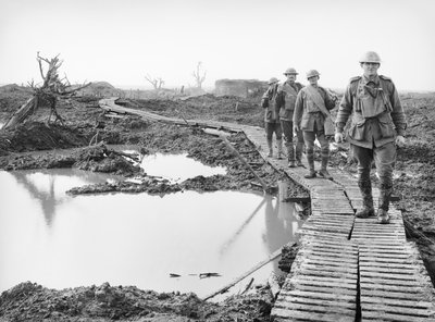 Čtyři australští vojáci kráčející po dráze duckboard v Tokiu poblíž Zonnebeke v sektoru Ypres nad částí země zajaté Australany v bojích třetí bitvy od Australian Photographer