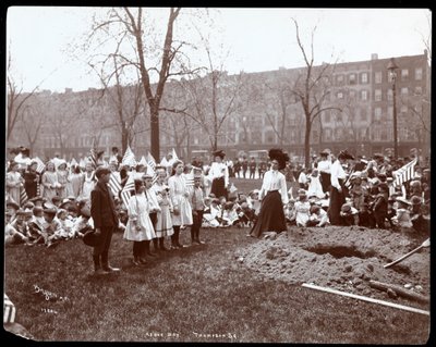 Dospělí a děti držící vlajky stojící kolem nově vykopané díry pro výsadbu stromu na Arbor Day v Tompkins Square Park, New York, 1904 (stříbrný želatinový tisk) od Byron Company