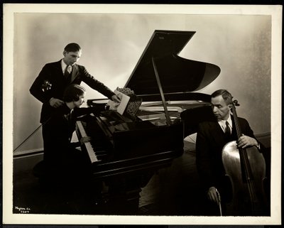Slepá žena, slečna Hardingová, u klavíru vyučující dva slepé muže na housle a violoncello, 1936 (stříbrný želatinový tisk) od Byron Company